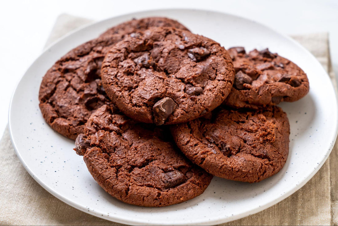 A plate of chocolate cookies arranged neatly on a white napkin.
